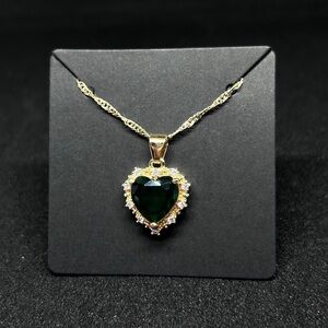 Woman’s Heart shaped pendant necklace with a gold tone chain and green stone
